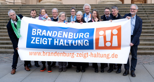Engagierte aus dem Bündnis gegen Rechts Namens Brandenburg zeigt Haltung halten Banner